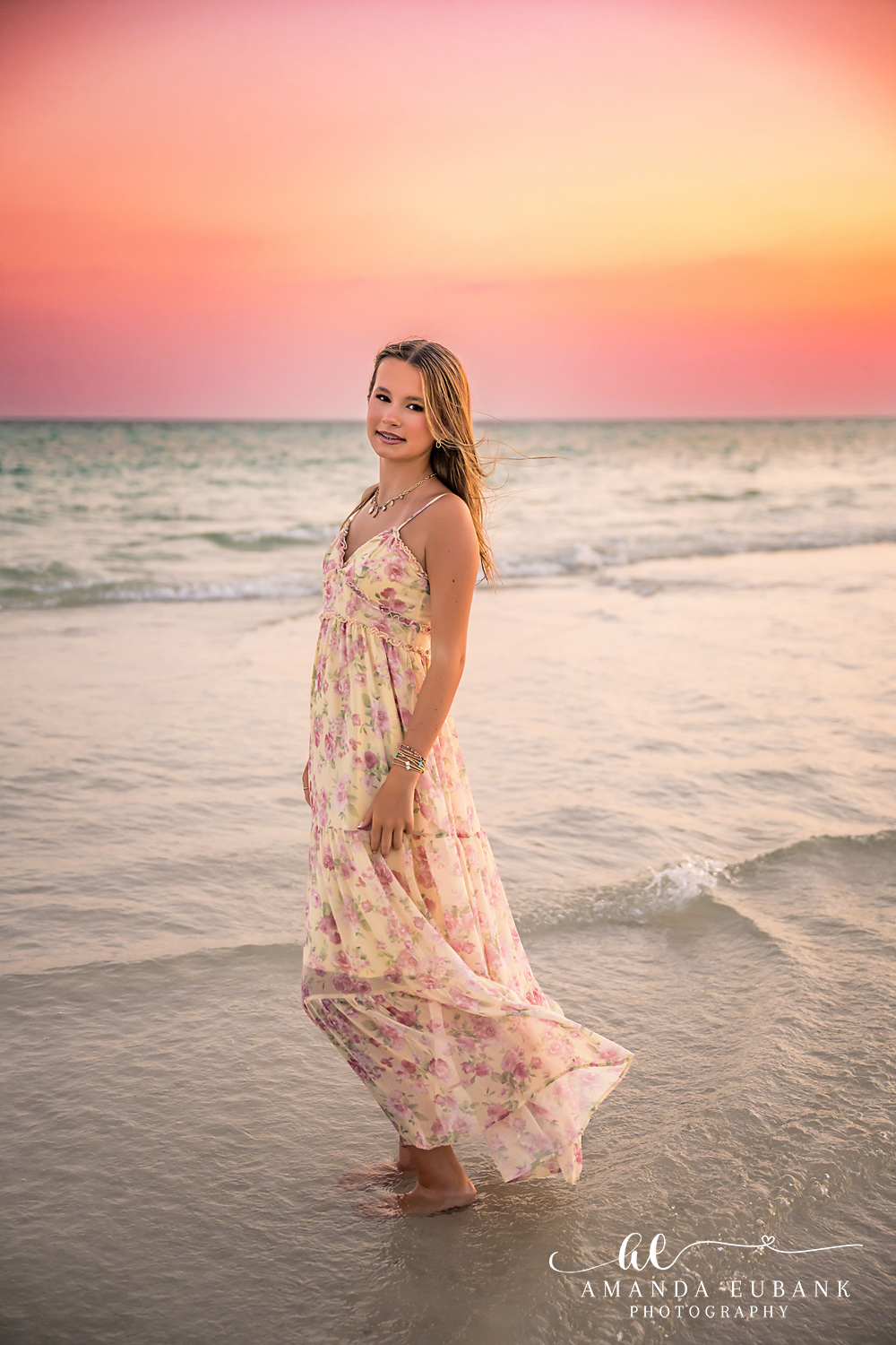 WaterSound Beach Sunset Portrait in Floral Maxi Dress Young woman in a flowing floral maxi dress standing in the surf at sunset on WaterSound Beach