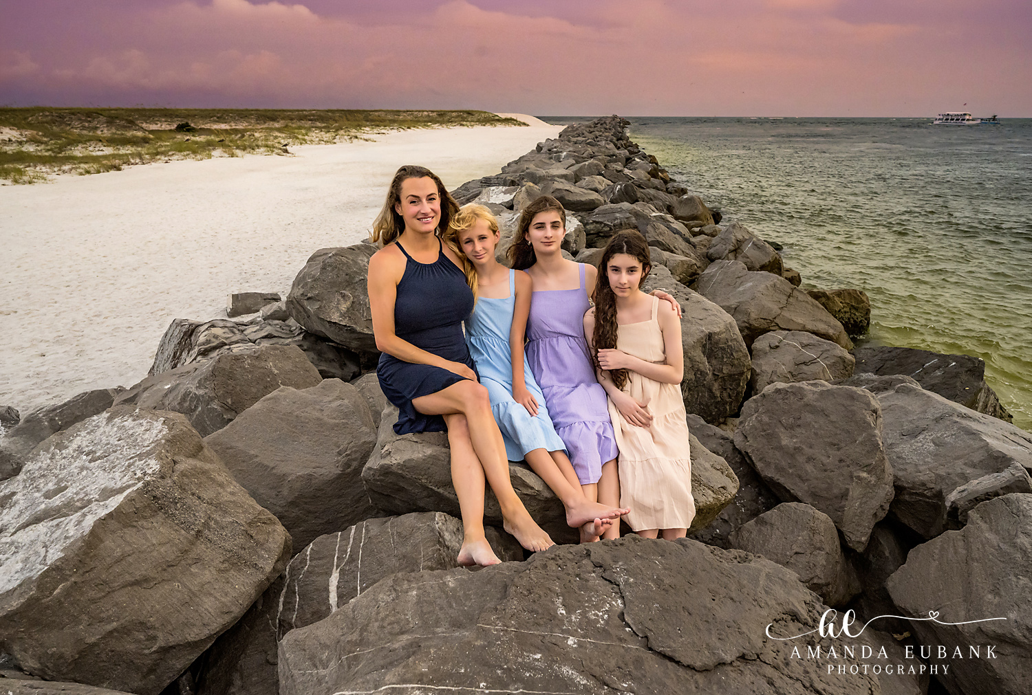 Destin Jetties Family Photos | Four girls posing together Four girls posing together on the rocks at the Destin Jetties in Destin, Florida at sunset, photographed by Destin family photographer Amanda Eubank