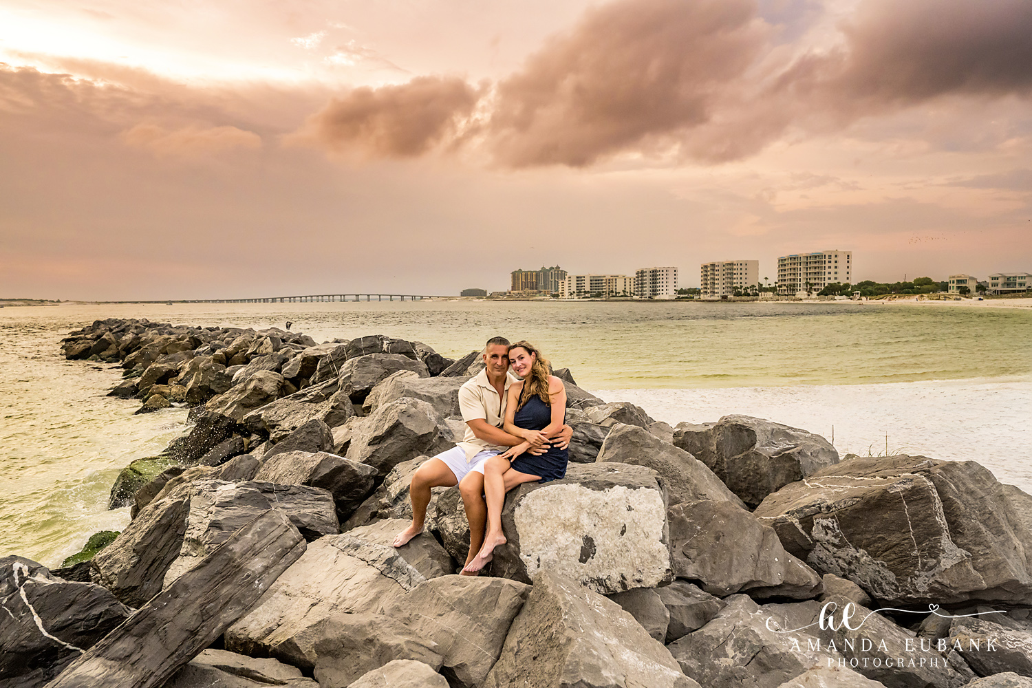 Destin Jetties Family Photos | Two kids sitting together Two kids sitting together on the rocks at the Destin Jetties in Destin, Florida at sunset, photographed by Destin family photographer Amanda Eubank
