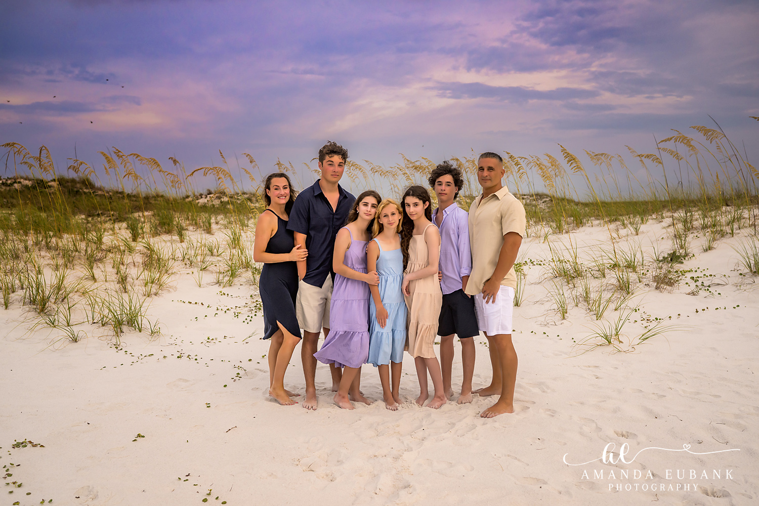 Destin Jetties Family Photos | Family lined up together A family lined up together among the sea oats and dunes near the Destin Jetties in Destin, Florida at sunset, photographed by Destin family photographer Amanda Eubank