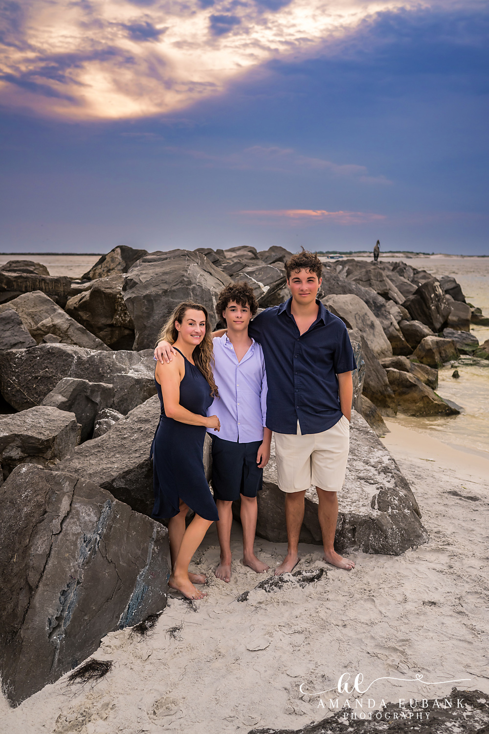 Destin Jetties Family Photos | Girl and two boys standing together A girl and two boys standing together on the rocks at the Destin Jetties in Destin, Florida at sunset, photographed by Destin family photographer Amanda Eubank