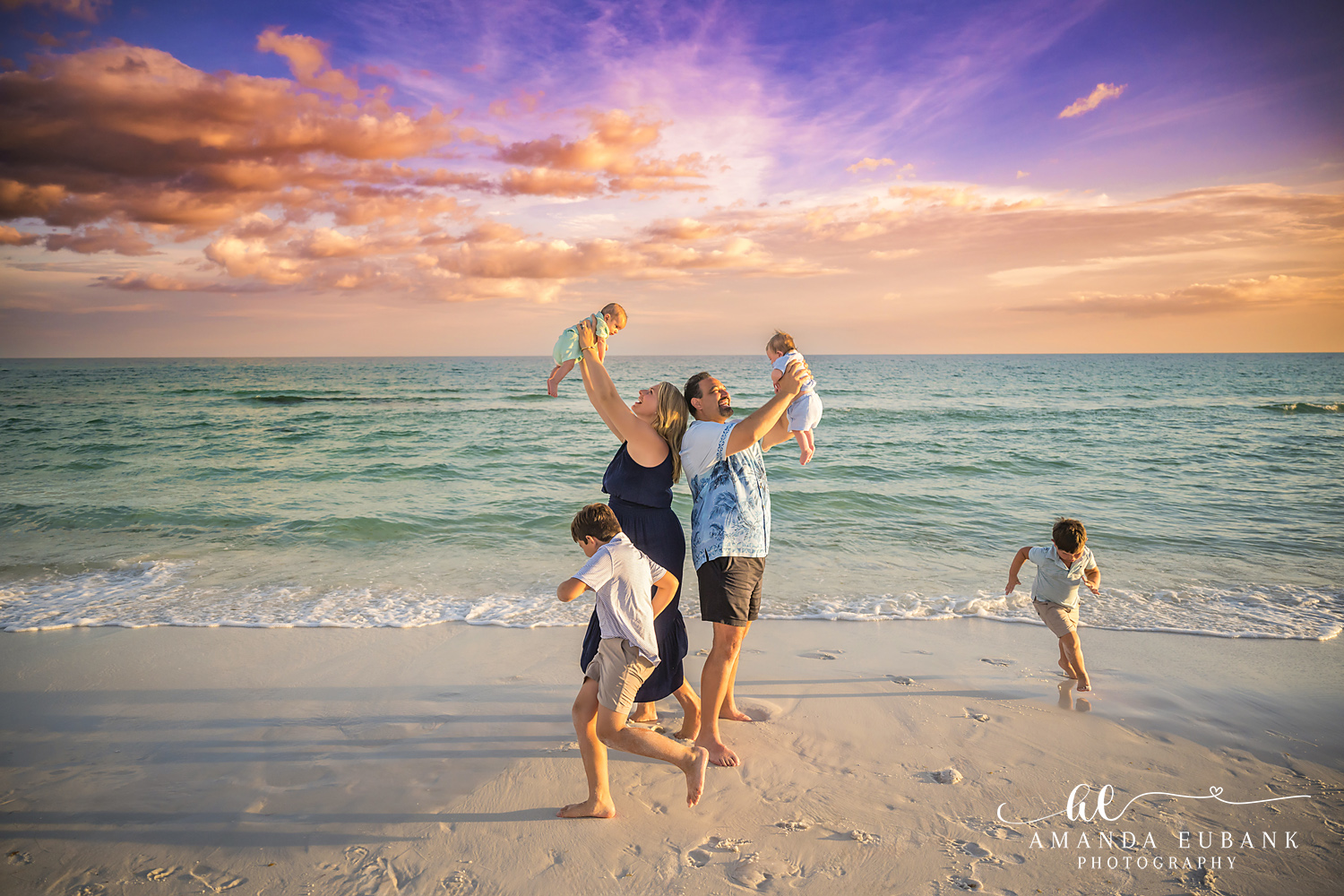 A playful family moment in the surf on the beach in Destin, Florida at sunset, photographed by Destin family photographer Amanda Eubank