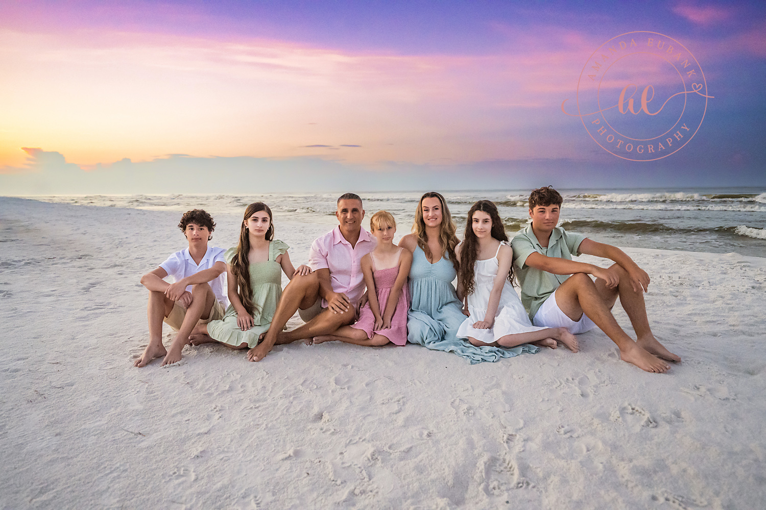 Miramar Beach Sunrise Family Photos | Family group sitting in the sand A family group sitting in the sand on the beach in Miramar Beach, Florida at sunrise, photographed by Miramar Beach family photographer Amanda Eubank