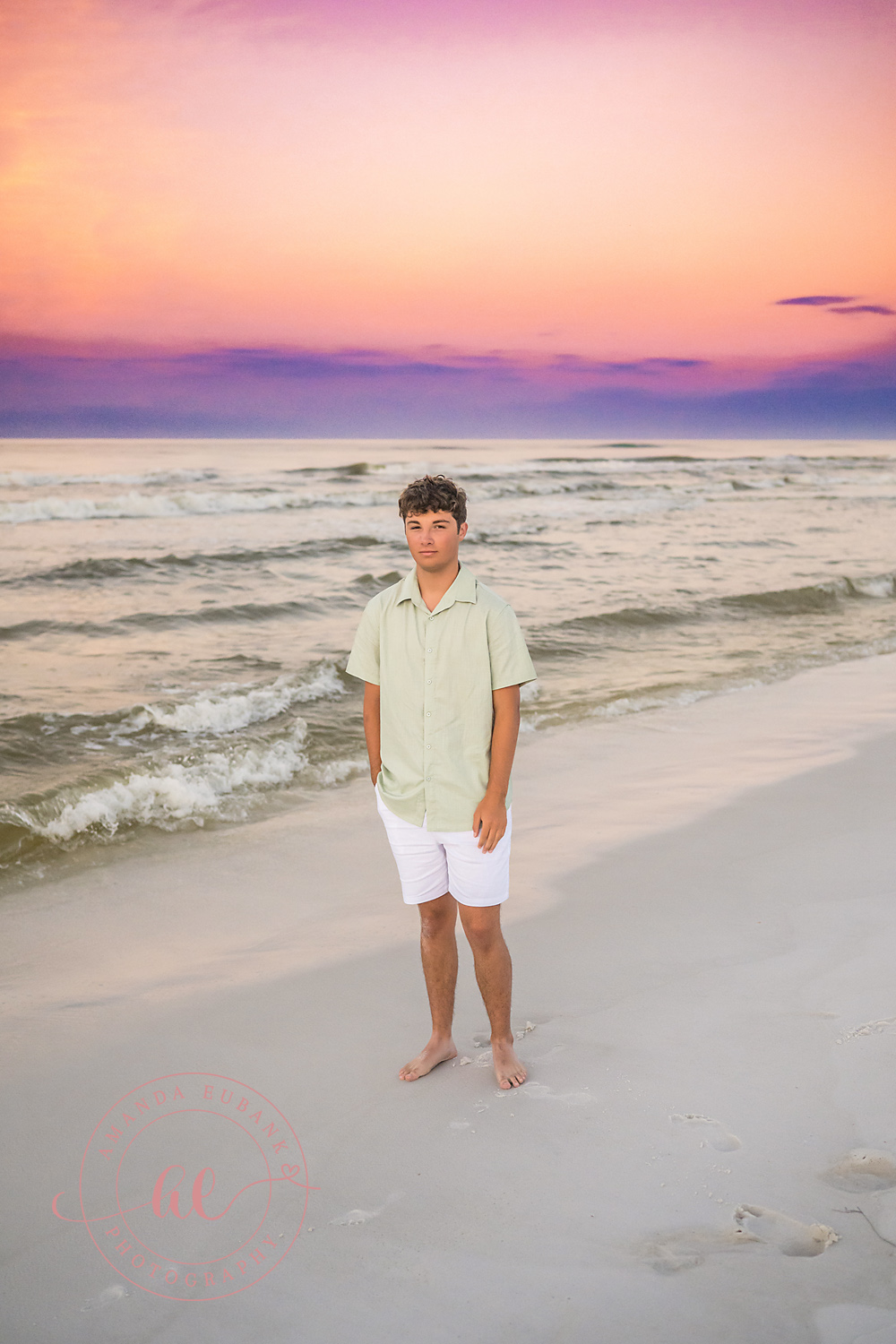 Miramar Beach Sunrise Family Photos | Teen boy standing on the shoreline A teen boy standing on the shoreline on the beach in Miramar Beach, Florida at sunrise, photographed by Miramar Beach family photographer Amanda Eubank