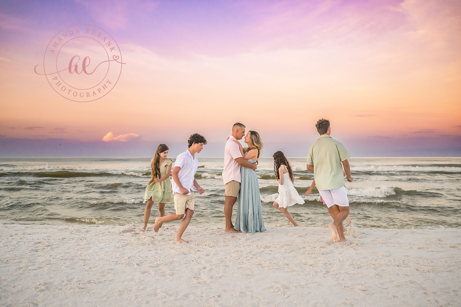 Miramar Beach Sunrise Family Photos | Playful family moment on the shoreline A playful family moment on the shoreline on the beach in Miramar Beach, Florida at sunrise, photographed by Miramar Beach family photographer Amanda Eubank