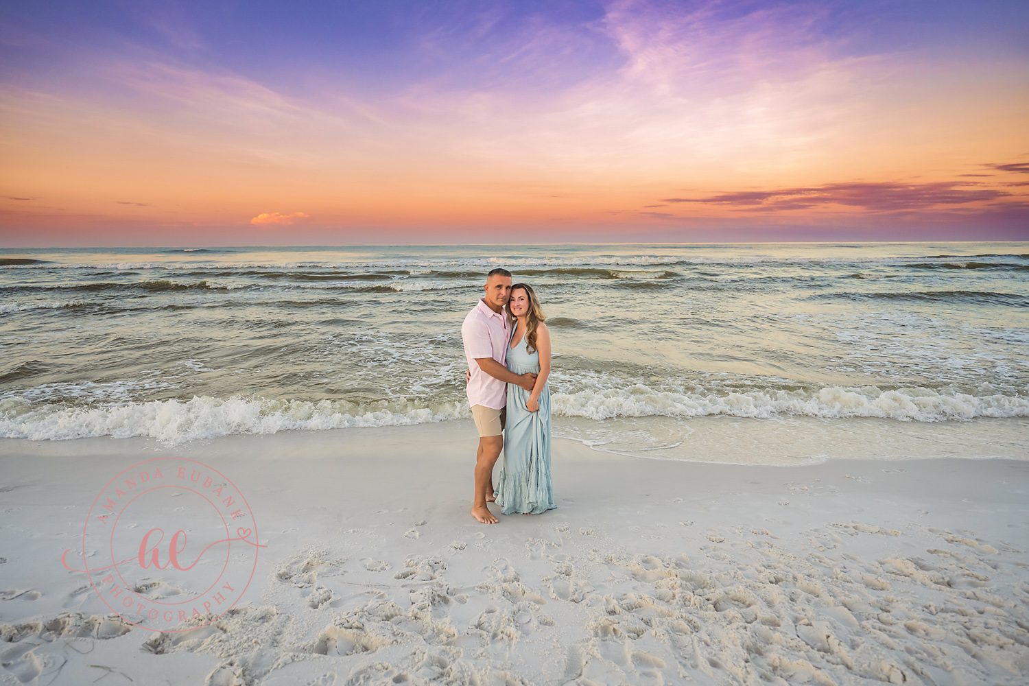 Miramar Beach Sunrise Family Photos | Couple embracing on the shoreline A couple embracing on the shoreline on the beach in Miramar Beach, Florida at sunrise, photographed by Miramar Beach family photographer Amanda Eubank