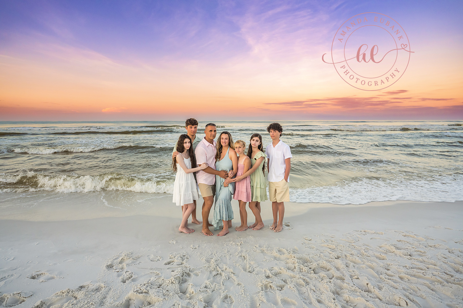 Miramar Beach Sunrise Family Photos | Family hugging close together A family hugging close together on the beach in Miramar Beach, Florida at sunrise, photographed by Miramar Beach family photographer Amanda Eubank
