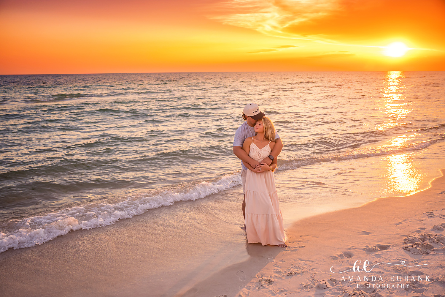 Rosemary Beach Family Photos | Couple embracing as the sun sets over the water A couple embracing as the sun sets over the water on the beach in Rosemary Beach, Florida at sunset, photographed by Rosemary Beach family photographer Amanda Eubank