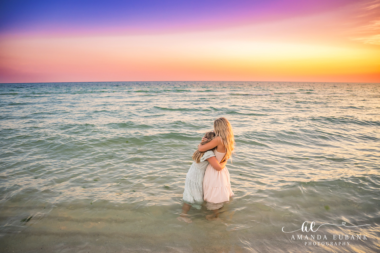 Rosemary Beach Family Photos | Mom and daughter hugging in the water Mom and daughter hugging in the water on the beach in Rosemary Beach, Florida at sunset, photographed by Rosemary Beach family photographer Amanda Eubank
