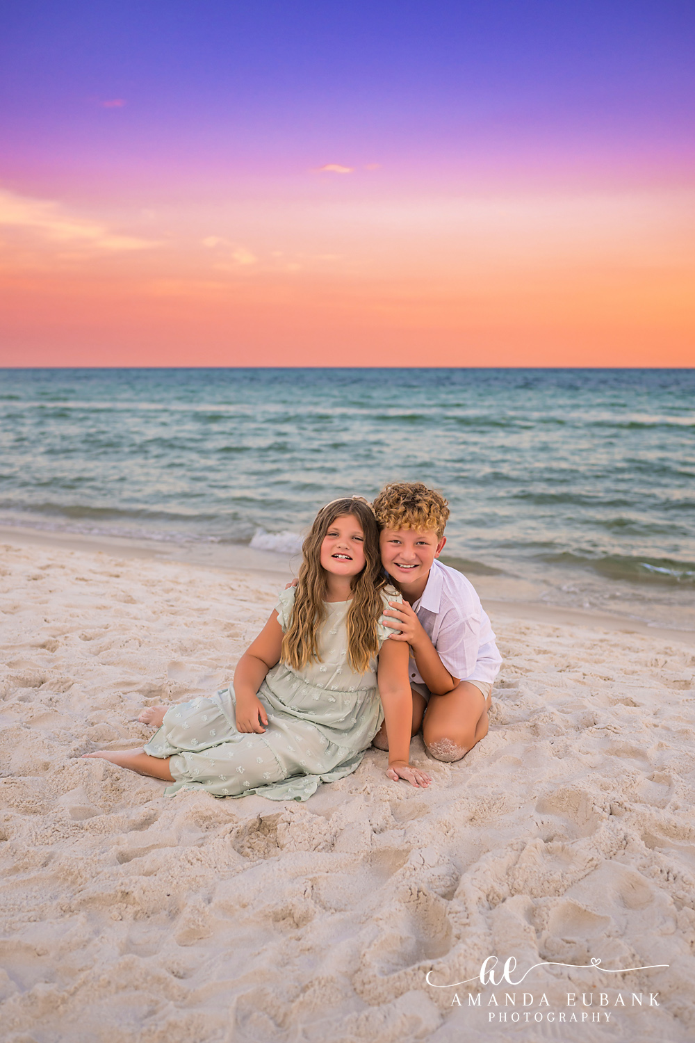 Rosemary Beach Family Photos | Brother and sister sitting in the sand A brother and sister sitting in the sand on the beach in Rosemary Beach, Florida at sunset, photographed by Rosemary Beach family photographer Amanda Eubank