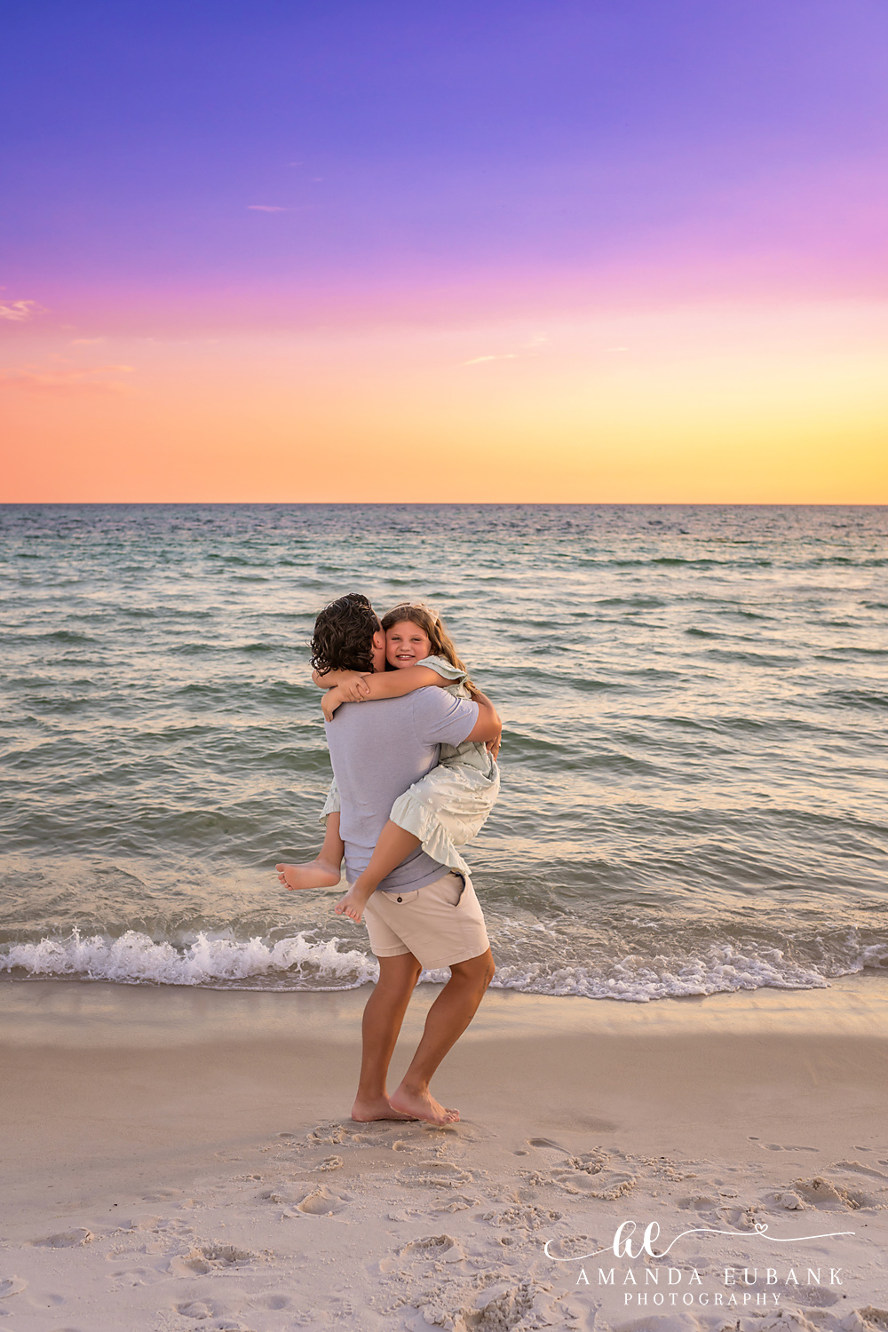 Rosemary Beach Family Photos | Dad lifting his child in a playful moment Dad lifting his child in a playful moment on the beach in Rosemary Beach, Florida at sunset, photographed by Rosemary Beach family photographer Amanda Eubank