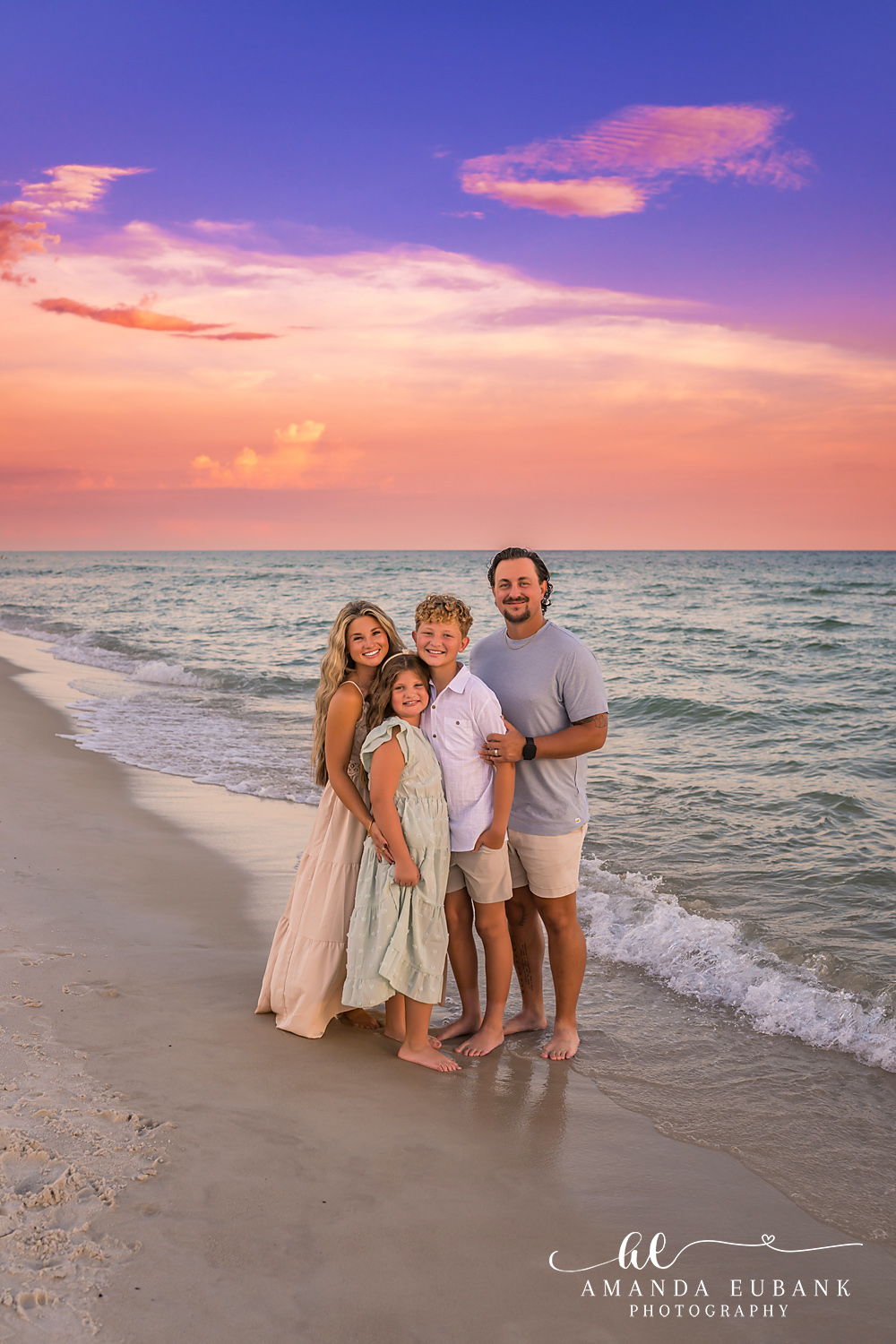 Rosemary Beach Family Photos | Family of four on the shoreline A family of four on the shoreline on the beach in Rosemary Beach, Florida at sunset, photographed by Rosemary Beach family photographer Amanda Eubank