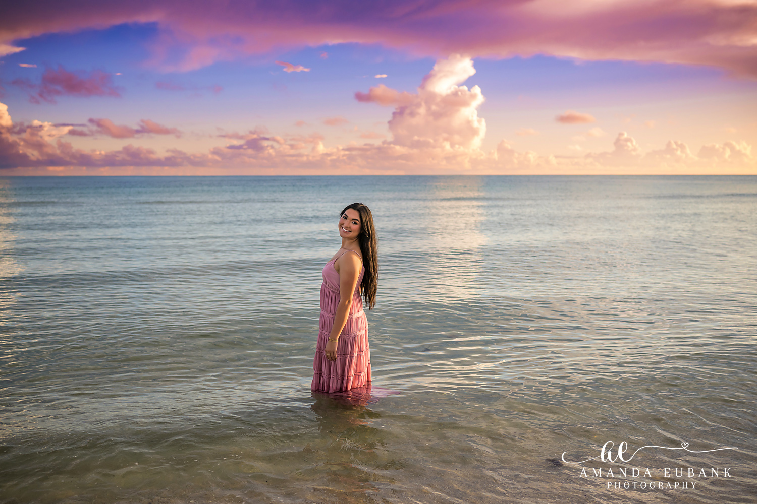 Rosemary Beach Senior Photos | Standing in the Gulf Rosemary Beach senior photographer: senior girl in a pink dress standing in the Gulf with wide pastel clouds above